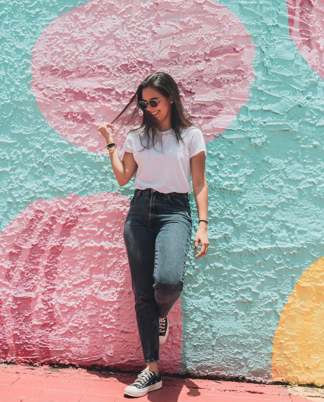 Valentina Alvarez standing in front of a pastel mural in Miami