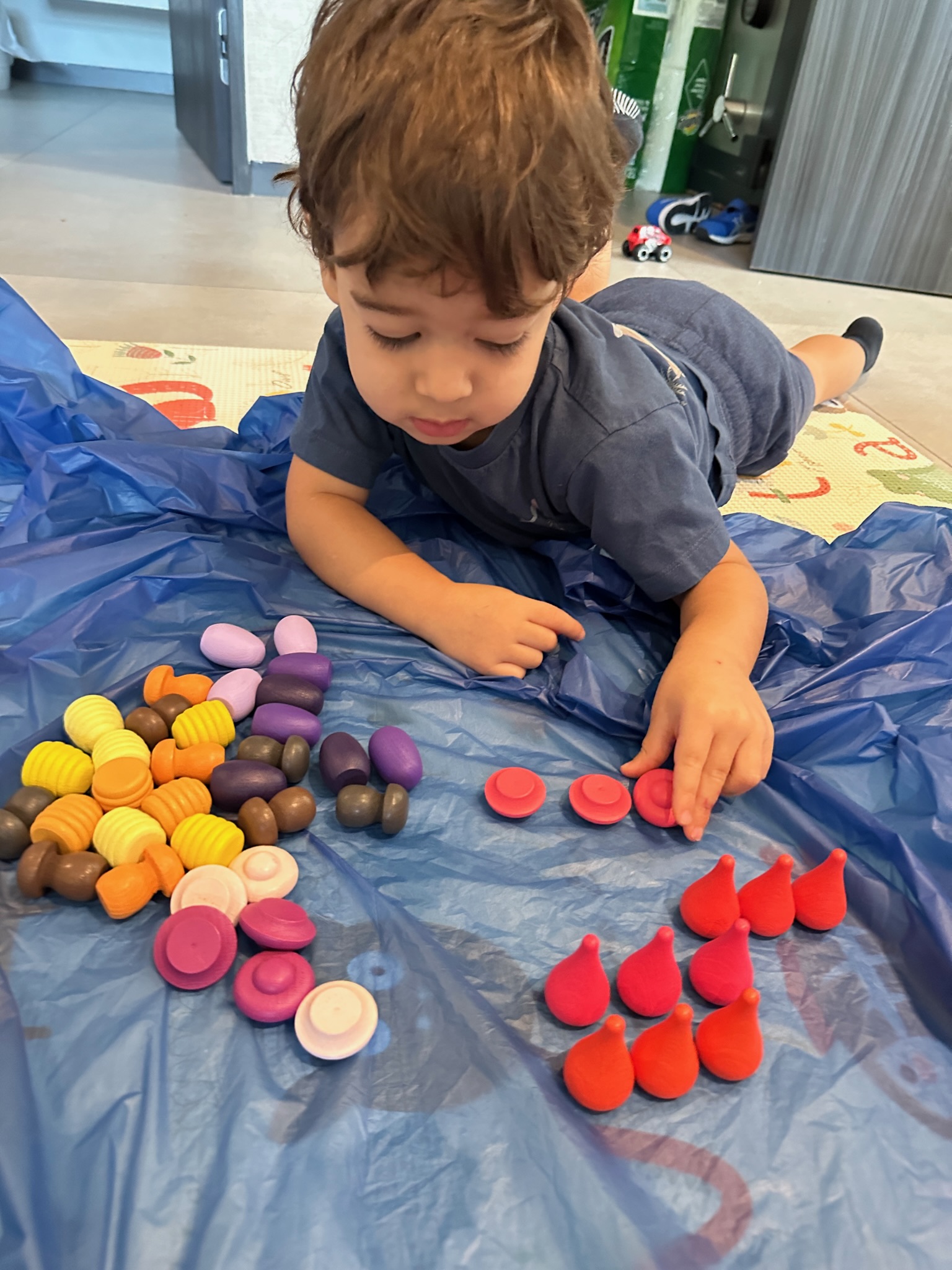A toddler sorting colorful wooden pieces