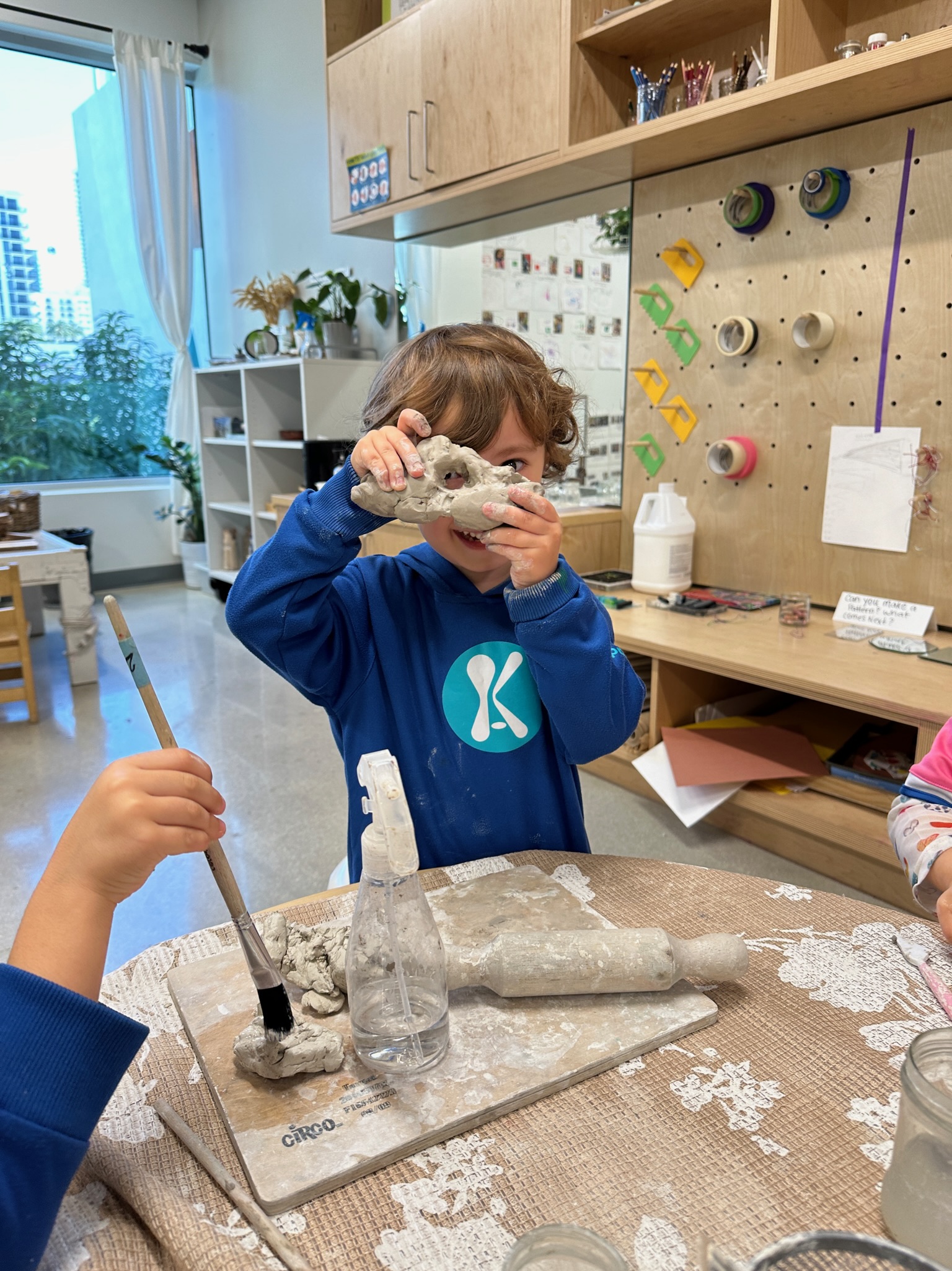 A child shaping clay at an art table