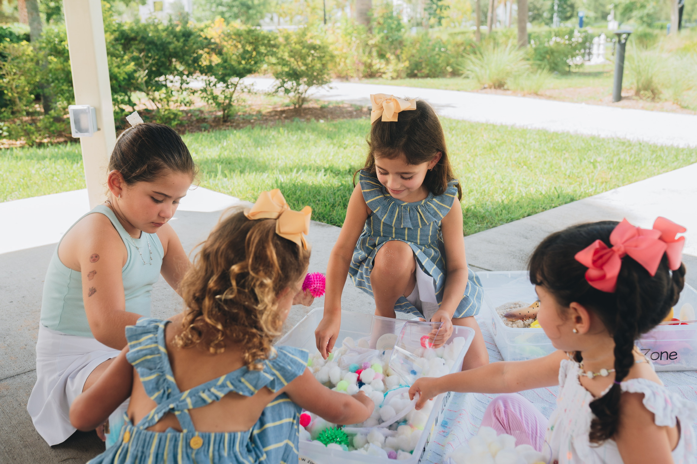Children exploring sensory bins together outdoors